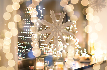 Image showing paper snowflake decoration hanging on window