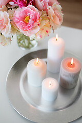 Image showing candles burning on table and flowers at cozy home