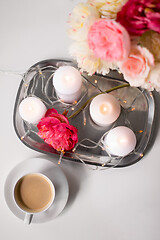 Image showing coffee, candles, garland and flowers on table