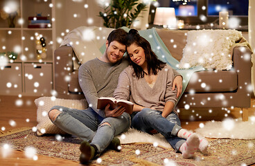 Image showing happy couple reading book at home