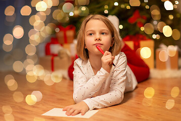 Image showing girl writing christmas wish list at home