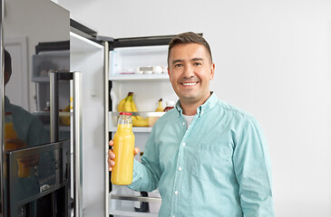 Image showing man taking juice from fridge at home kitchen