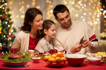 Image showing family with smartphone having christmas dinner