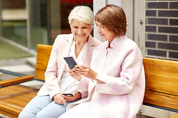 Image showing happy senior women with smartphones in city