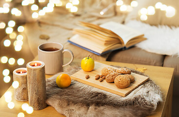 Image showing cookies, lemon tea and candles on table at home