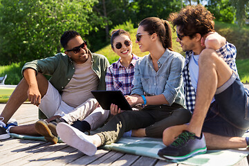 Image showing friends with tablet pc computer outdoors in summer