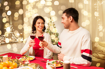 Image showing happy couple drinking red wine at christmas dinner