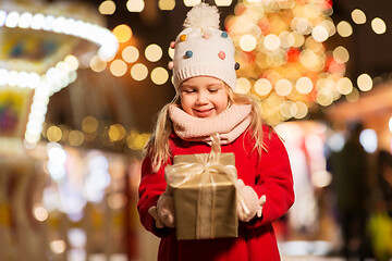 Image showing happy girl with gift box at christmas market