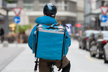 Image showing Courier On Bicycle Delivering Food In City.