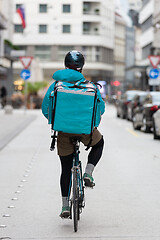 Image showing Courier On Bicycle Delivering Food In City.