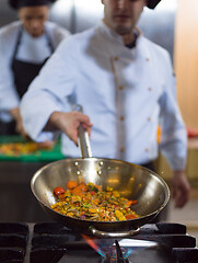 Image showing chef flipping vegetables in wok