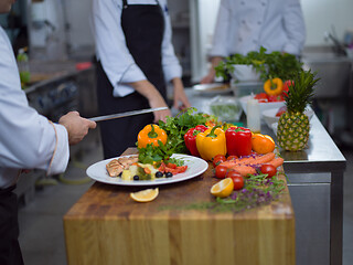 Image showing cook chef decorating garnishing prepared meal