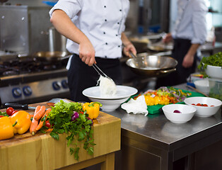 Image showing Chef hands serving spaghetti