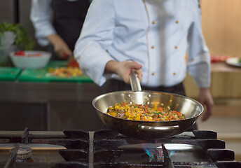 Image showing chef flipping vegetables in wok