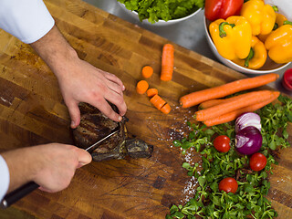 Image showing closeup of Chef hands preparing beef steak