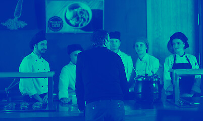 Image showing chefs in the kitchen presenting dish of tasty meal