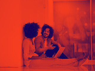 Image showing multiethnic couple using a laptop on the floor