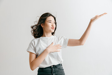 Image showing The happy asian woman standing and smiling against gray background.