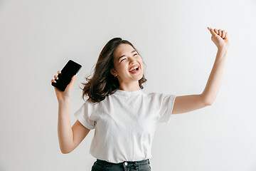 Image showing Portrait of a confident casual asian girl showing blank screen of mobile phone