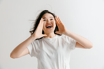 Image showing Isolated on pink young casual woman shouting at studio