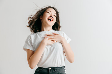 Image showing Happy asian woman standing and smiling against gray background.