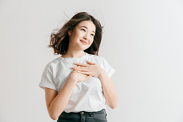 Image showing Happy asian woman standing and smiling against gray background.