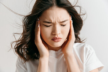 Image showing Woman having headache. Isolated over gray background.