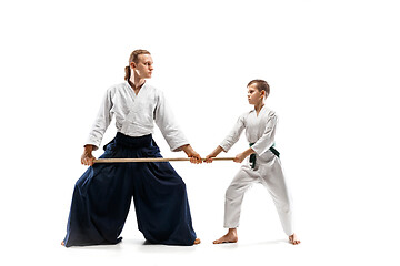 Image showing Man and teen boy fighting with wooden swords at Aikido training in martial arts school
