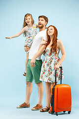 Image showing Happy parent with daughter and suitcase at studio isolated on blue background