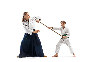 Image showing Man and teen boy fighting with wooden swords at Aikido training in martial arts school