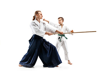 Image showing Man and teen boy fighting with wooden swords at Aikido training in martial arts school