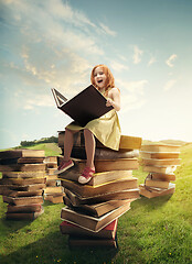 Image showing Little Girl sitting on the tower made of big books