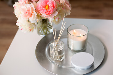 Image showing aroma reed diffuser, candle and flowers on table