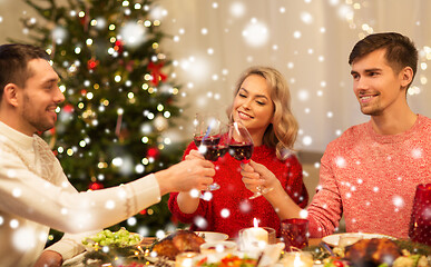 Image showing happy friends drinking red wine at christmas party