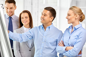 Image showing happy business team with flip chart at office