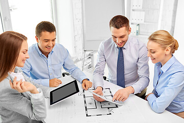 Image showing happy business team discussing blueprint at office