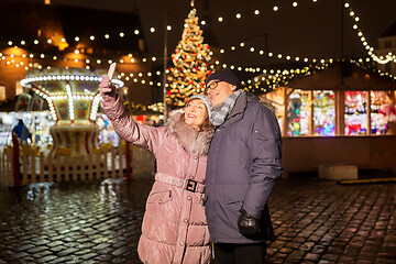 Image showing senior couple taking selfie at christmas market