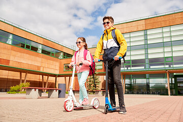 Image showing happy school children with backpacks and scooters