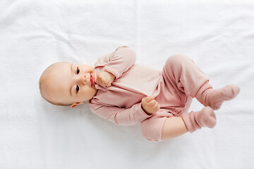 Image showing sweet baby girl lying on white blanket