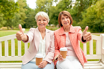 Image showing senior women with coffee showing thumbs up at park