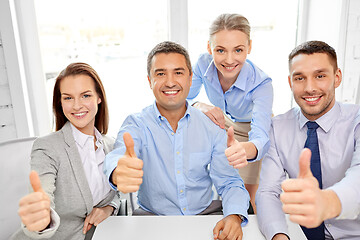 Image showing happy business team showing thumbs up at office