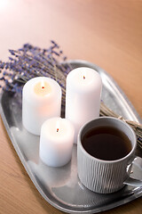 Image showing candles, tea in mug and lavender flowers on table