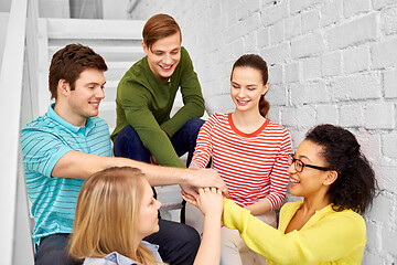 Image showing teenage friends or students stacking hands