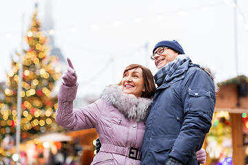 Image showing happy senior couple hugging at christmas market