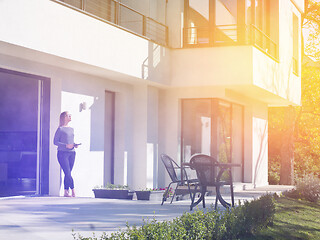 Image showing women using tablet computer in front of luxury home villa