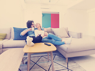 Image showing Young couple on the sofa watching television