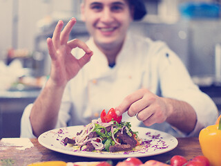 Image showing cook chef decorating garnishing prepared meal