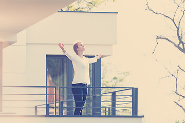 Image showing woman stretching her arms on balcony