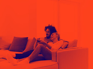 Image showing Young couple on the sofa watching television