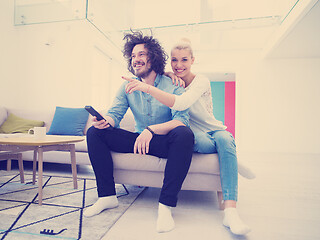 Image showing Young couple on the sofa watching television